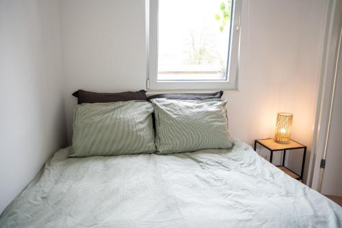 a bedroom with a bed with two pillows and a window at Huisje Kerkepad in Gorredijk