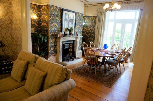Una sala de estar con un sofá, una mesa y sillas. en Spacious Town House with Swimming Pool, en Plymouth