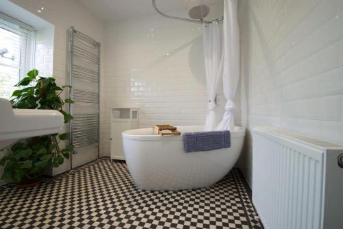 y baño con bañera blanca y lavamanos. en Spacious Town House with Swimming Pool, en Plymouth