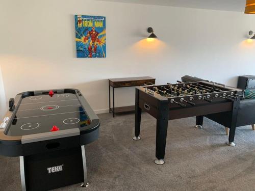 two ping pong tables in a room with a game at The Mariners' Beacon Torquay in Torquay