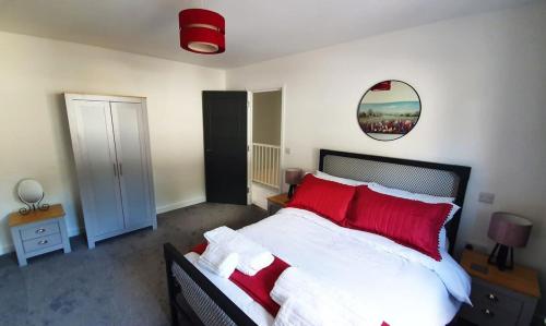 a bedroom with a large bed with red pillows at The Mariners' Beacon Torquay in Torquay