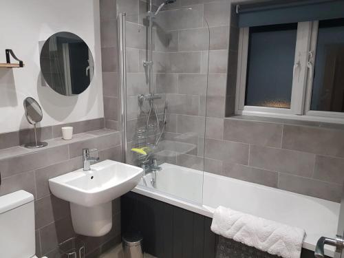a bathroom with a sink and a toilet and a shower at The Mariners' Beacon Torquay in Torquay
