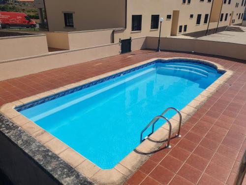 a large swimming pool on top of a building at Apartamento Ancora Caldebarcos in San Mamede de Carnota