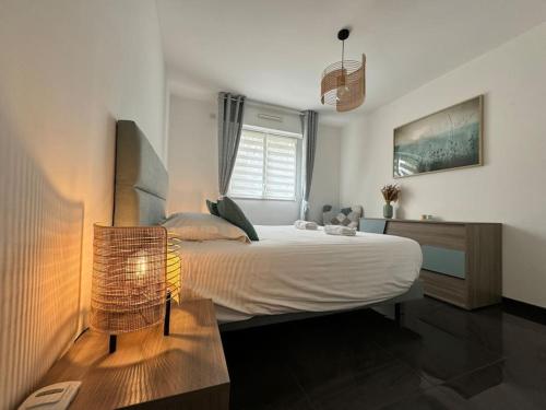 une chambre avec un lit, une table et une fenêtre dans l'établissement Le Mas des Oliviers : Apt 4 Prs, Piscine, Parking, à Antibes