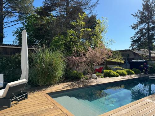 - une piscine dans une cour avec une terrasse en bois dans l'établissement Villa basquaise avec piscine, à Andernos-les-Bains