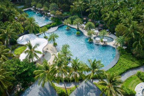 an aerial view of a resort pool with palm trees at InterContinental Phu Quoc Long Beach Resort, an IHG Hotel in Phú Quốc