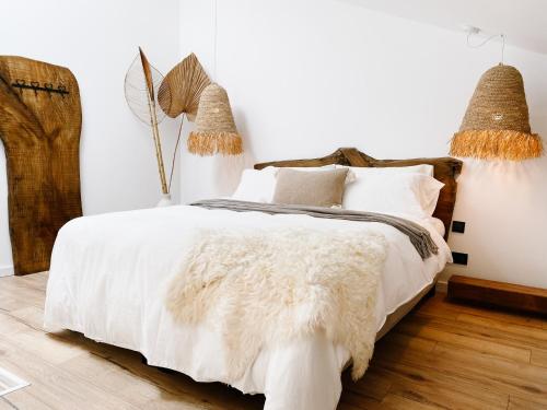 a bedroom with a bed with white sheets and pillows at 57 Bee OLD TOWN Lagos - Character House near Beach & Marina in Lagos