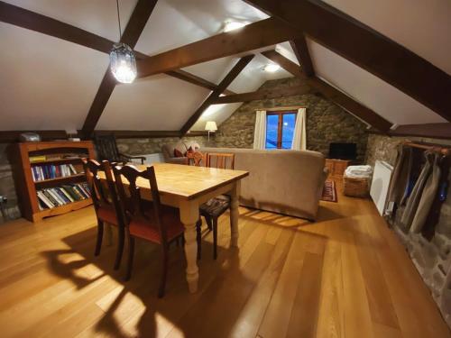 a dining room with a wooden table and chairs at Idyllic Dartmoor Cottage in Postbridge