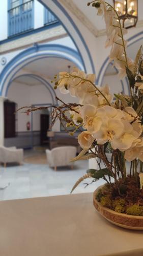 a vase filled with white flowers on a table at Casa Palacio Don Pedro in Seville