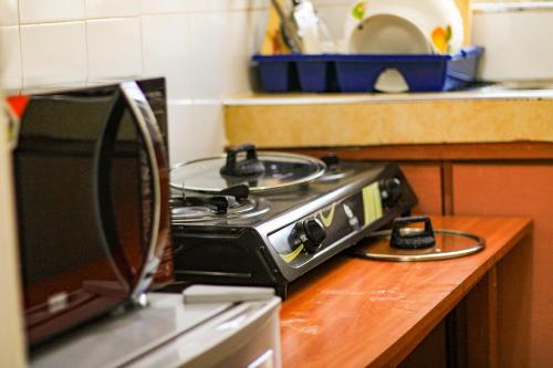a stove top oven sitting on top of a kitchen counter at Cosy Homes Eldoret in Eldoret