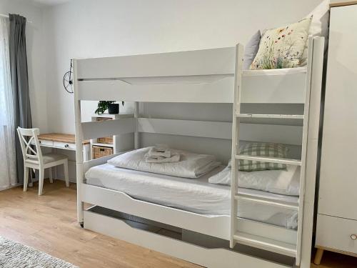 a white bunk bed in a room with a desk at Appartio-80qm-ländlich-luxuriös 