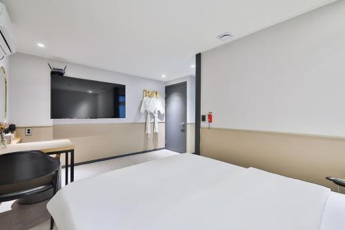 a bedroom with a bed and a desk and a television at No 25 Hotel Namyangju Bukhan River in Namyangju