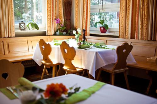 a dining room with two tables and chairs with flowers at isarwinkel in Geretsried