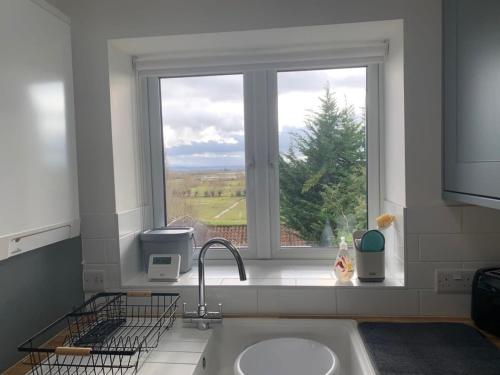 uma cozinha com um lavatório e uma janela em Stunning Hillside House em Langport