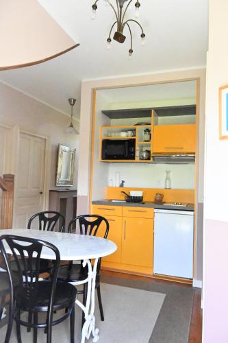 une cuisine avec une table et des chaises dans une pièce dans l'établissement Jardin Madeleine, à Morlaix