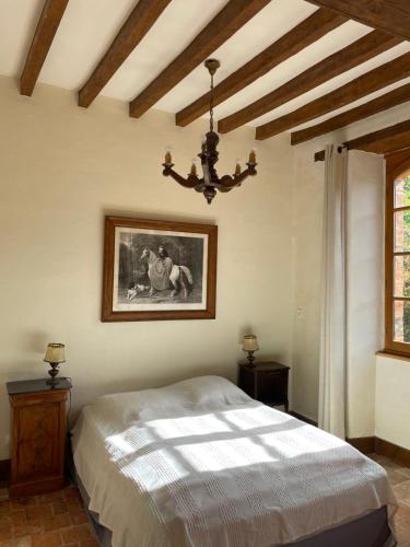 a bedroom with a bed and a picture on the wall at Domaine de la Haute-Porte in Souvigné-sur-Sarthe