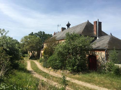 an old house with a dirt road next to it at Domaine de la Haute-Porte in Souvigné-sur-Sarthe