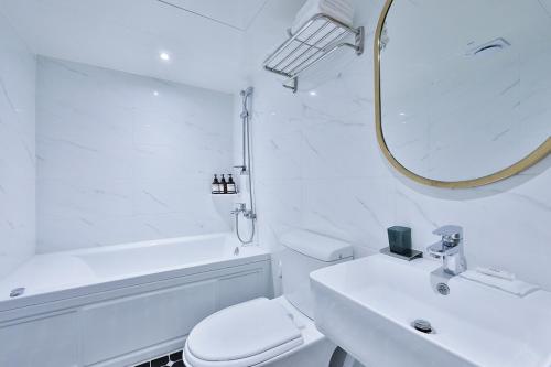 a bathroom with a toilet and a sink and a mirror at No 25 Hotel Namyangju Bukhan River in Namyangju