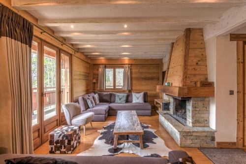 a living room with a couch and a fireplace at Chalet Les Cimes - Welkeys in Praz-sur-Arly