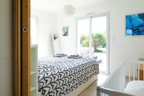 une chambre avec un lit avec une couverture noire et blanche dans l'établissement Maison récente proche centre-ville, les Sables 8 personnes, à Les Sables-dʼOlonne