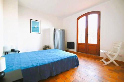 - une chambre avec un lit bleu et un réfrigérateur dans l'établissement Haut de Villa vue mer dégagée-T3, à La Seyne-sur-Mer