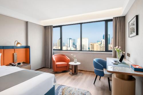 杭州市にあるLan'ou International Hotel - Wulin Square West Lakeのベッドとデスクが備わるホテルルームです。