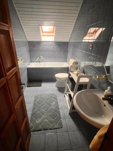 a bathroom with a tub and a toilet and a sink at Juhász Apartman in Gyenesdiás