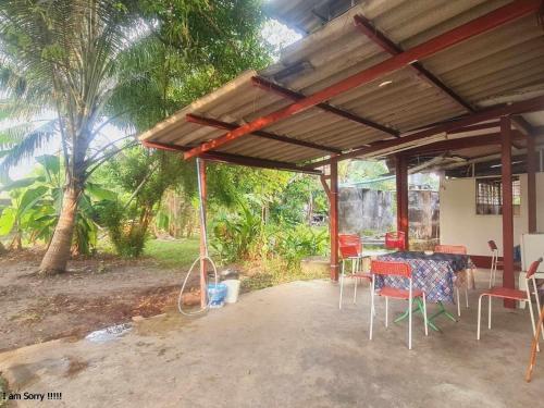 eine Terrasse mit einem Tisch und Stühlen unter einem Pavillon in der Unterkunft Anya's garden house Phuket oldtown in Ban Lo Long
