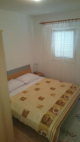 Un dormitorio con una cama con una manta. en Apartment Kiko, en Rogoznica