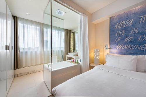 a bedroom with a bed and a bathroom with a sink at N’vY Manotel in Geneva