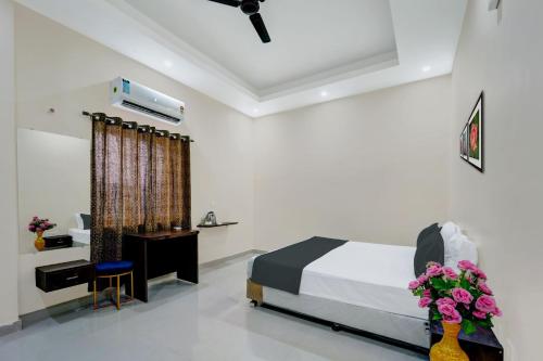 DānāpurにあるOYO Flagship The Elegance Resortのベッドルーム1室(ベッド1台、デスク、花付)