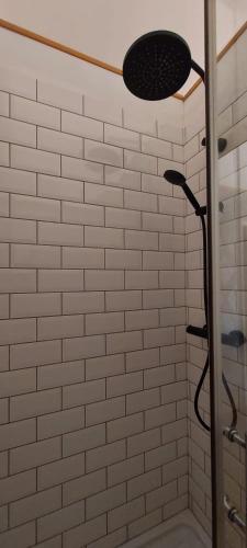 a white tiled shower with a shower head at B&B Bon Vivant in Brinay