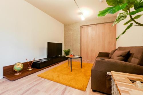 uma sala de estar com um sofá e uma televisão em Seirai Asakusa Vacation Rental - 3 minutes from station em Tóquio