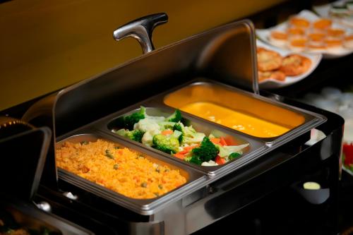 ein Tablett mit Brokkoli und anderen Lebensmitteln in Avertis in der Unterkunft Hanoi Harmonia Hotel & Spa in Hanoi