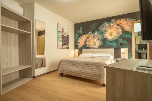 ランペドゥーザにあるホテル ノーティックの花の絵画が飾られたベッドルーム1室