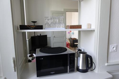 un micro-ondes posé sur un comptoir dans une cuisine dans l'établissement Lons-le Saunier Appartement Site remarquable, à Lons-le-Saunier