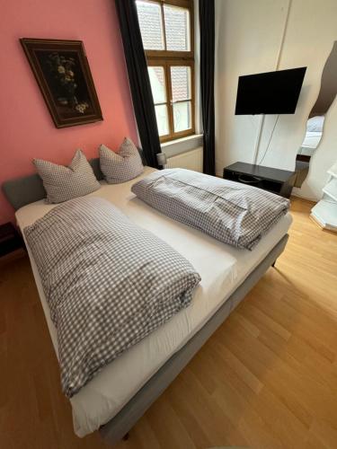 a bed with two pillows on it in a bedroom at Gasthaus Fischerrosl in Münsing am Starnberger See