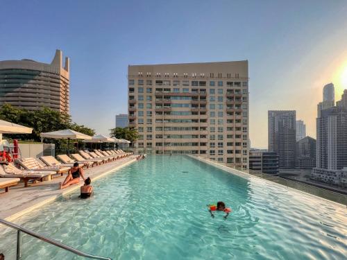 a pool on top of a building with people in the water at GuestReady - High-floor luxury with Marina view in Dubai