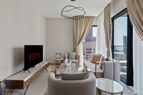 a living room with a couch and a tv at GuestReady - High-floor luxury with Marina view in Dubai