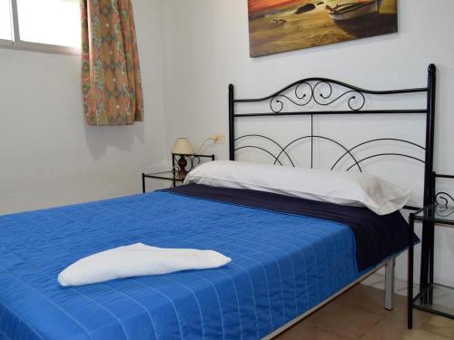 a bedroom with a blue bed with a black frame at Bungalows Peñismar II 3000 in Peniscola