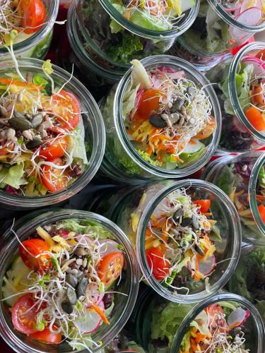 a bunch of plastic containers filled with salad dishes at Gasthaus Fischerrosl in Münsing am Starnberger See