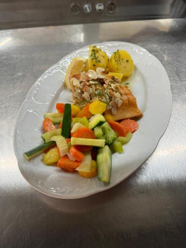 a plate of food with vegetables on a table at Gasthaus Fischerrosl in Münsing am Starnberger See
