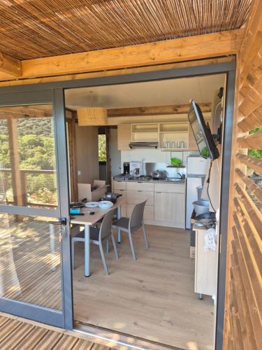 a kitchen and dining room with a table and chairs at Chalet maisonette dans hameau calme in Bonifacio