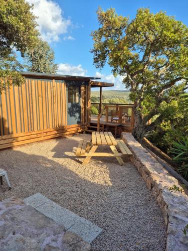 una cabina con tavolo e panca in un cortile di Chalet maisonette dans hameau calme a Bonifacio