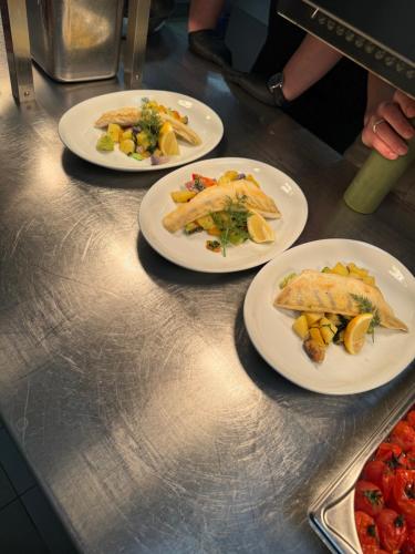 three plates of food sitting on a counter at Gasthaus Fischerrosl in Münsing am Starnberger See