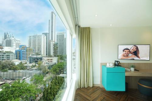a room with a window with a view of a city at SQ Boutique Hotel Managed by The Ascott Limited in Bangkok