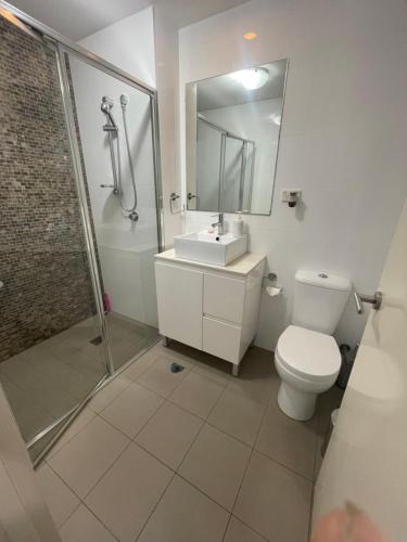 uma casa de banho com um WC, um chuveiro e um lavatório. em Ocean view 2 Bedroom apartment em Sydney