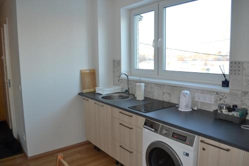a kitchen with a sink and a washing machine at Erra Guest Apartement in Erra