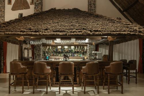 a bar with a group of chairs around it at Lake Manyara Kilimamoja Lodge in Mto wa Mbu