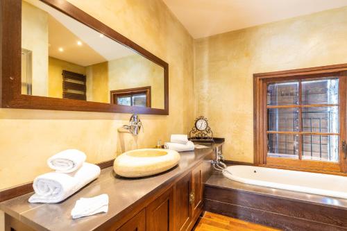a bathroom with a sink and a tub and a mirror at Domaine du Reginu in Santa-Reparata-di-Balagna